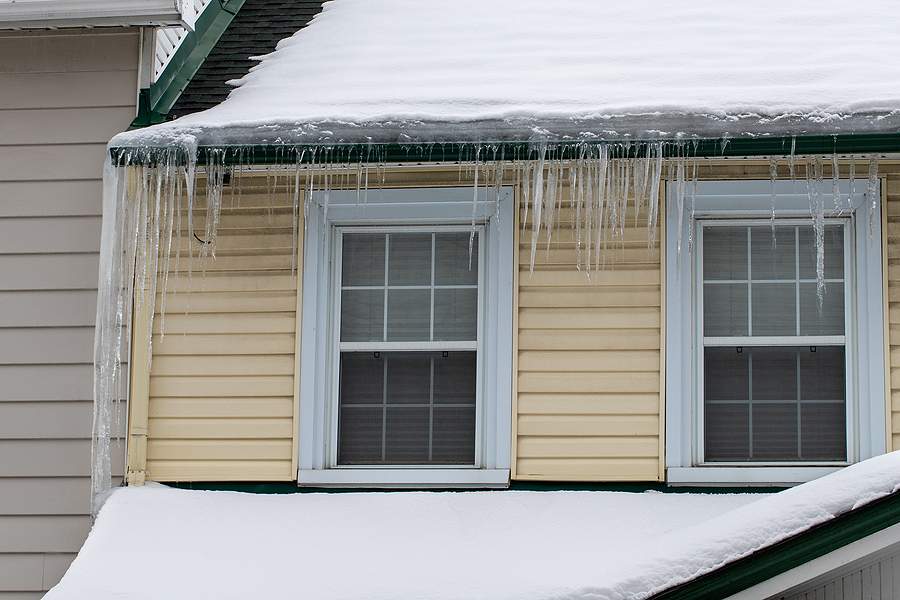 bigstock Icicles Hanging On A Roof Of T 470338259
