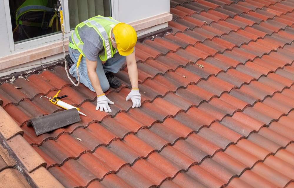 construction worker is inspecting roof tile cracked