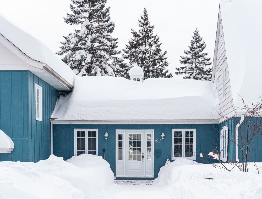 vertical shot blue house covered with white snow in winter